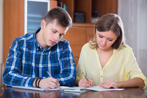 Couple-sitting-at-table-making-list-of-home-features